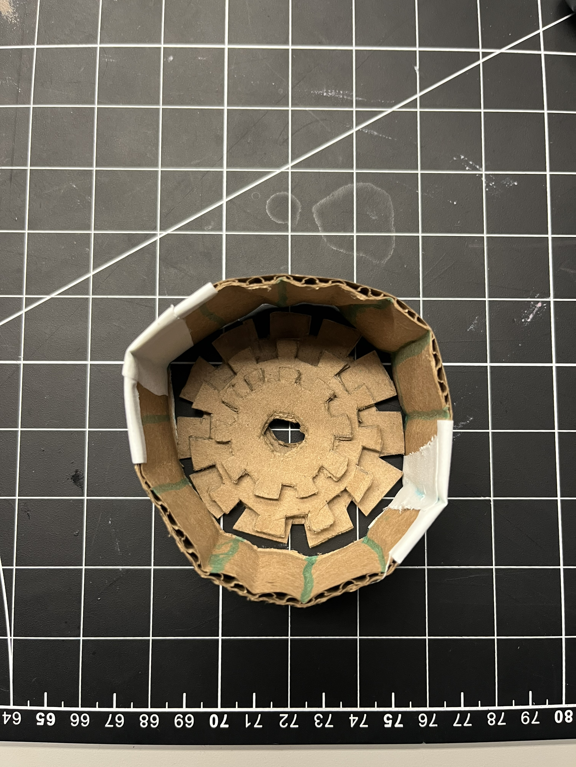 And this is what our prototype looked like. Even though it was very rough, it made us realize that it would be very hard to achieve what we wanted our wearable to do with gears, just because there's a lot of things that need to be very precise. For example, we couldn't use cardboard because it's too flimsy. We wouldn't be able to do laser cutting and use wood because if the gears shift, it might break as well too, and as well as the edges might be a little too sharp. And depending on the type of wood that we can get, it might also be too thin. And 3D modeling would also be hard because the gears need to be a very specific thickness, and the teeth have to be in the right place and direction. So after our second gorilla prototyping and talking to Steve, we decided not to do the gears just because there's a lot of things that go into it, and there's a lot of room for error to occur.